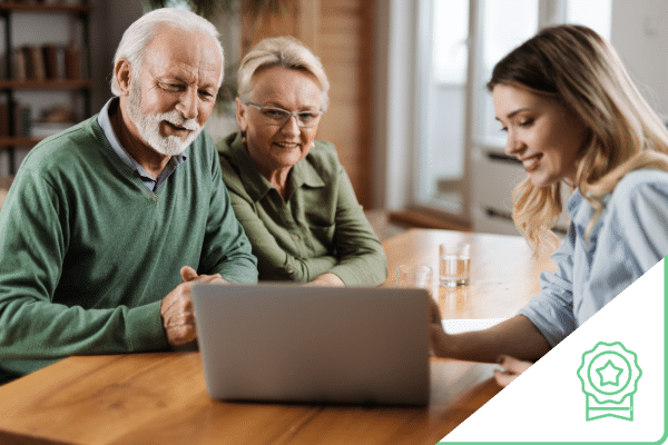 Older couple looking at computer screen with professional woman pointing to it