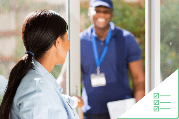 Woman talking to construction worker who is standing outside front door