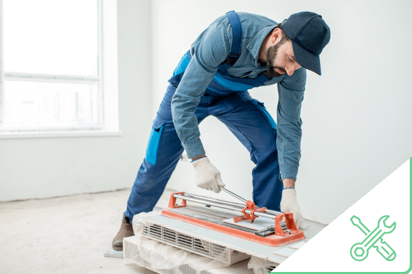 Construction worker cutting tile inside home for remodel job