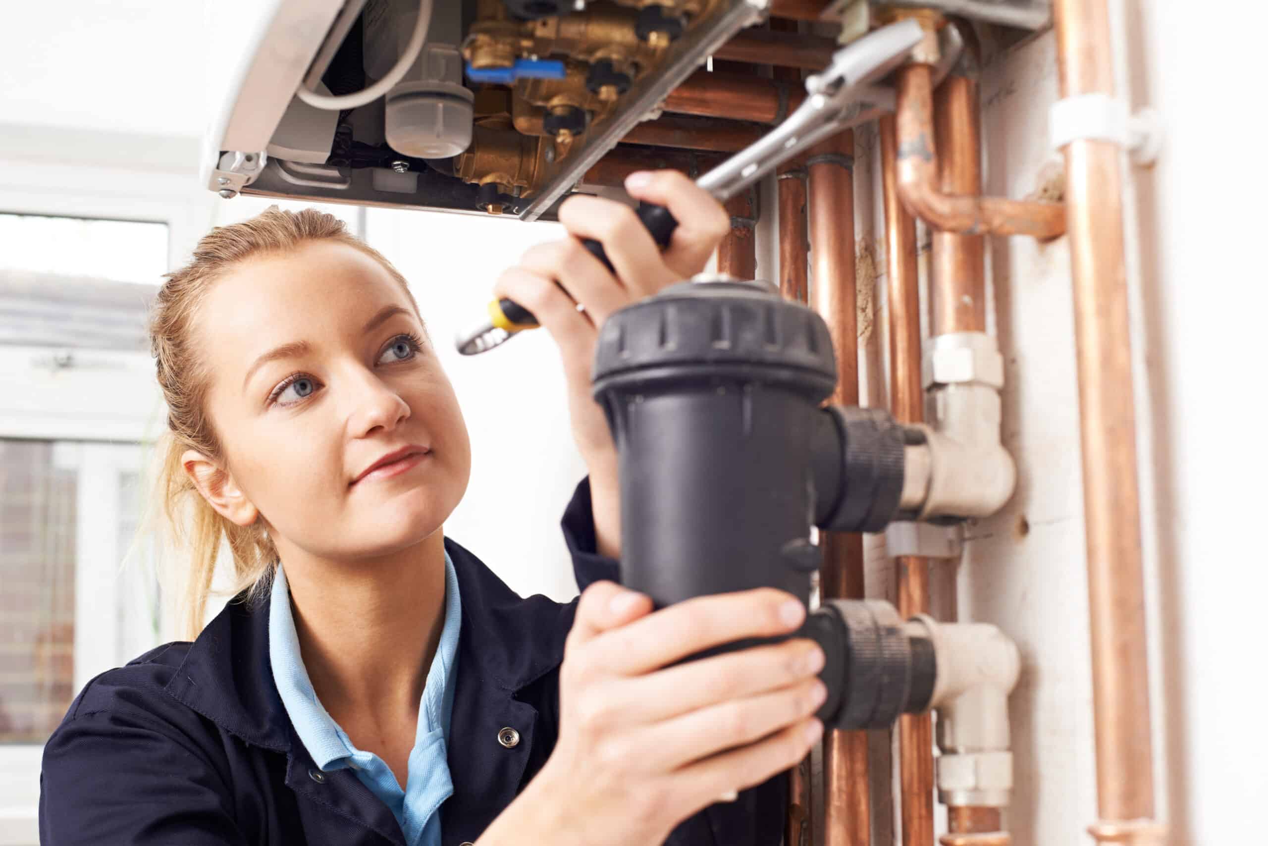 Female plumber installing water filter system