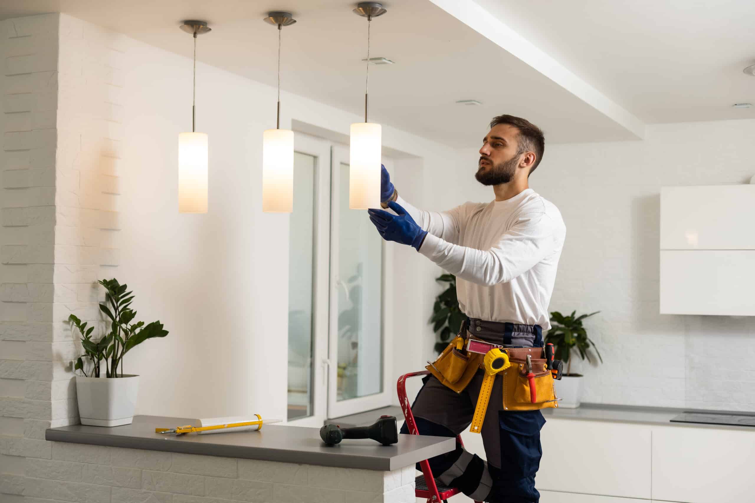 Construction worker installing lighting in home