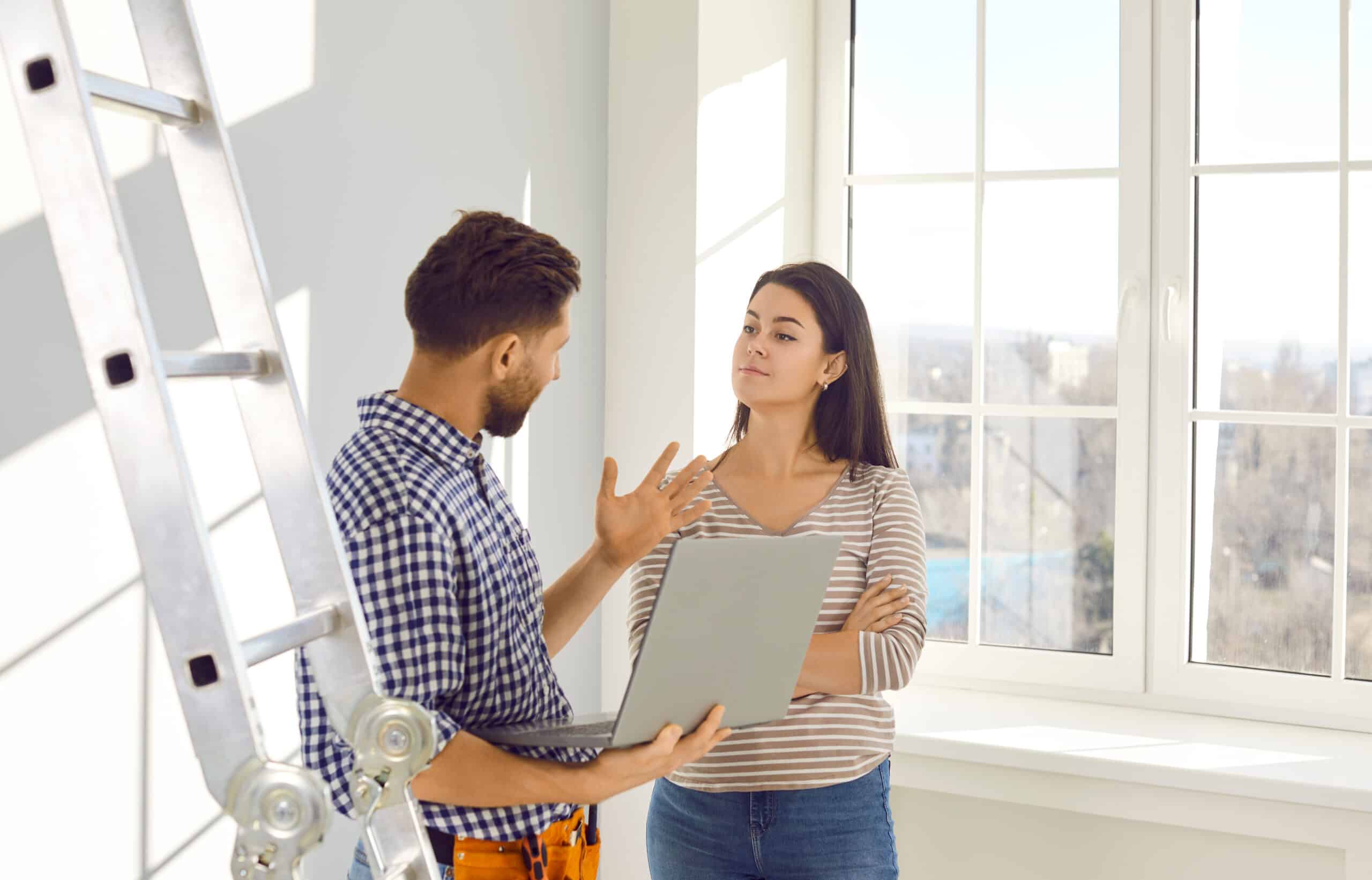 Construction worker talking with customer in home