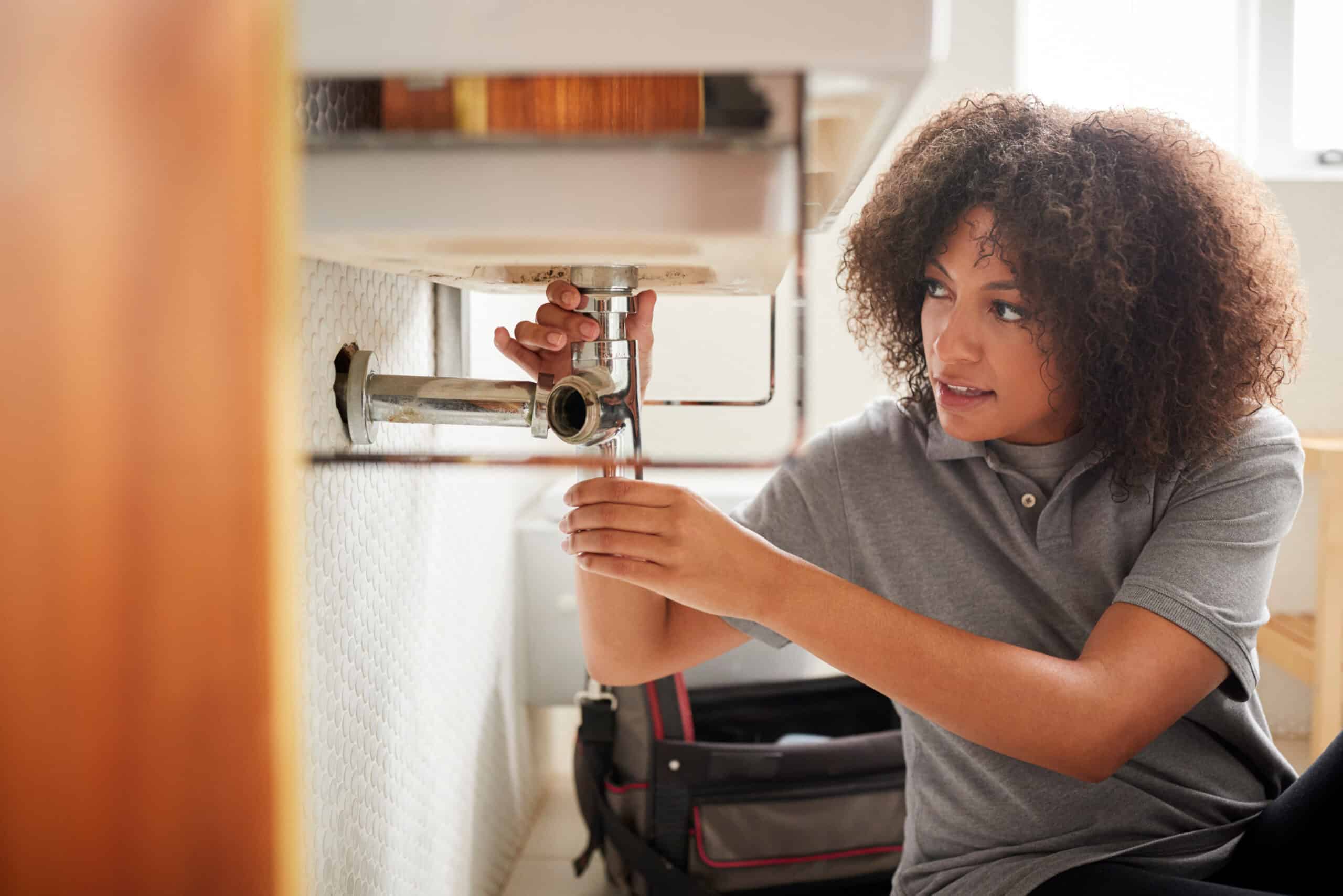 Black female construction worker installing accessible bathroom vanity