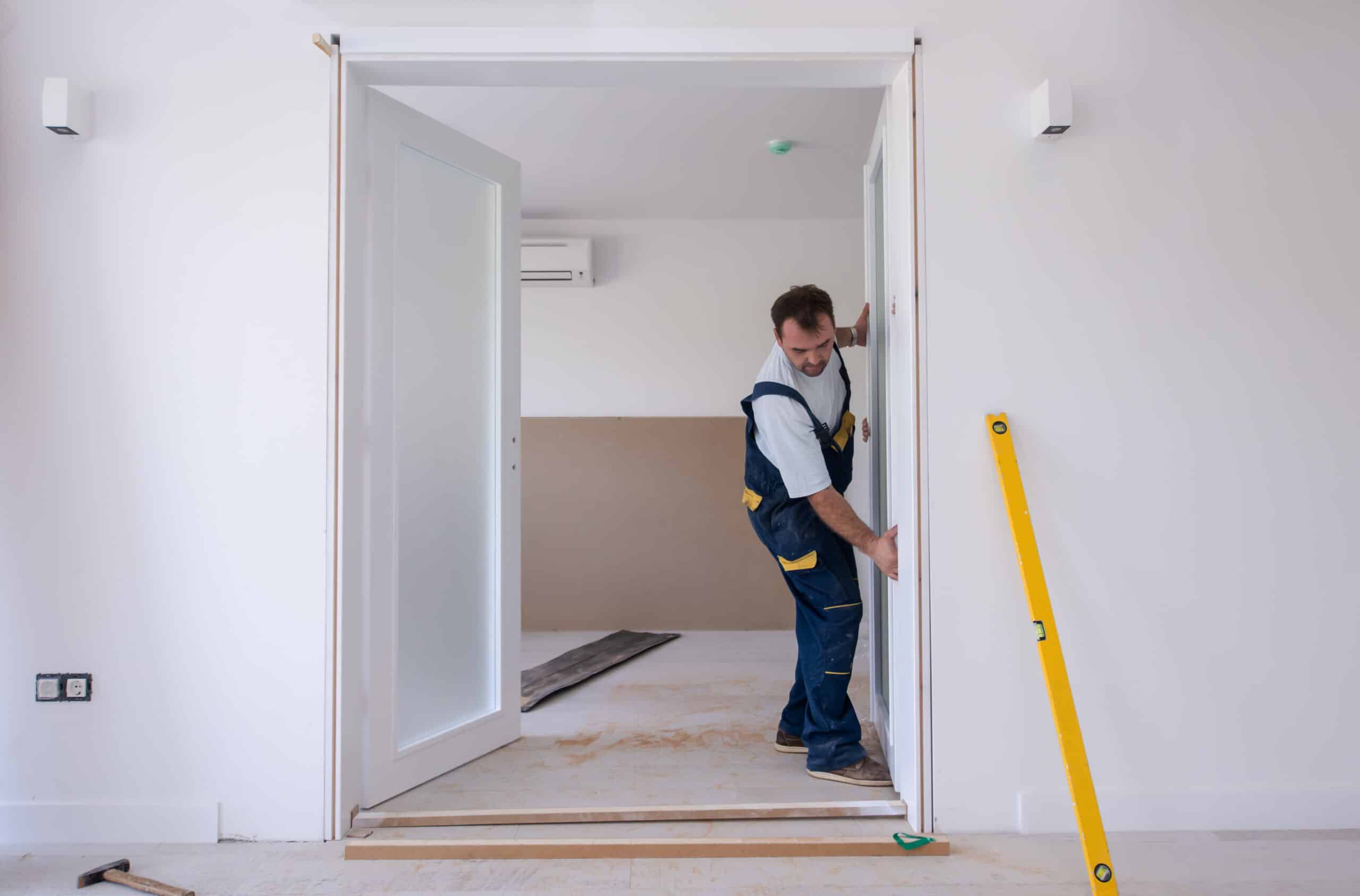 Construction worker widening doorway in home