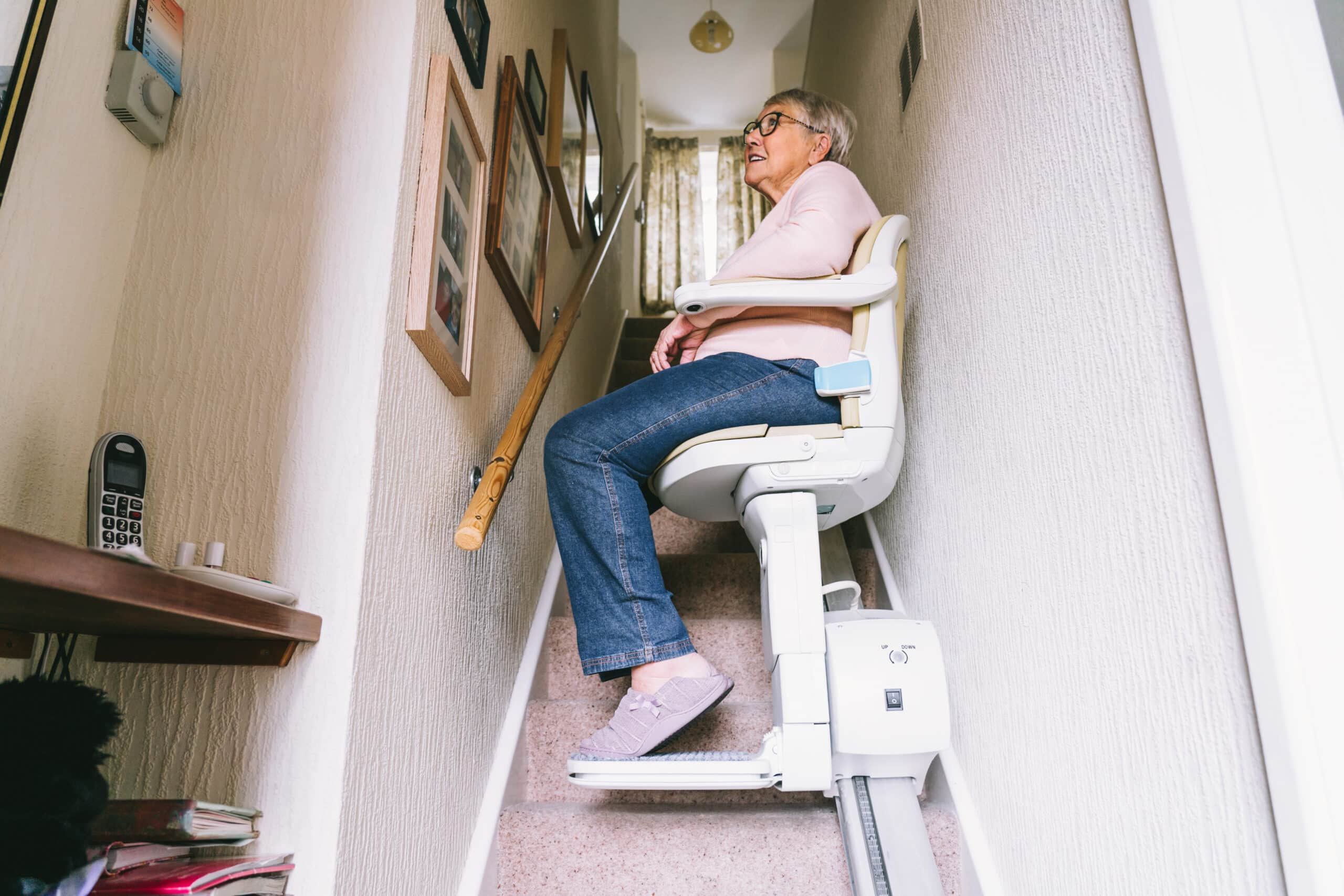 Elderly woman using stairlift in home